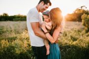 How Life insurance can protect your personal finances: Young couple standing in a field holding their baby